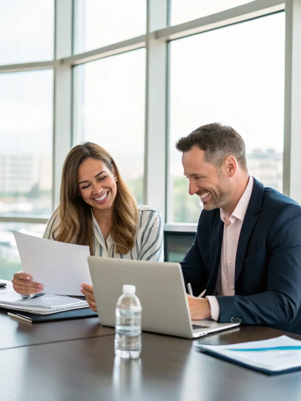 A logistics manager negotiating flexible contract terms with a supplier, both reviewing agreement details in a modern office setting.